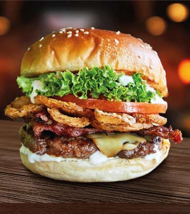 Stacked burger with bacon, onion rings and lettuce