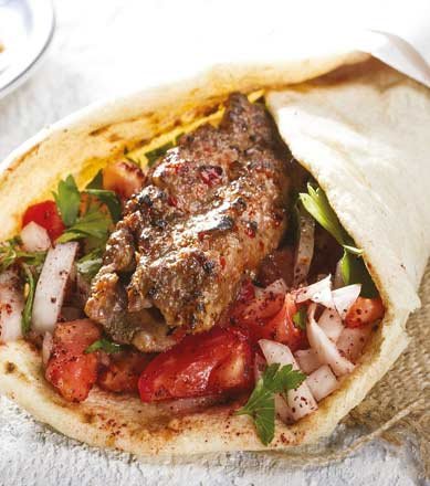 Doner kebab wrapped in naan with salad and sauce